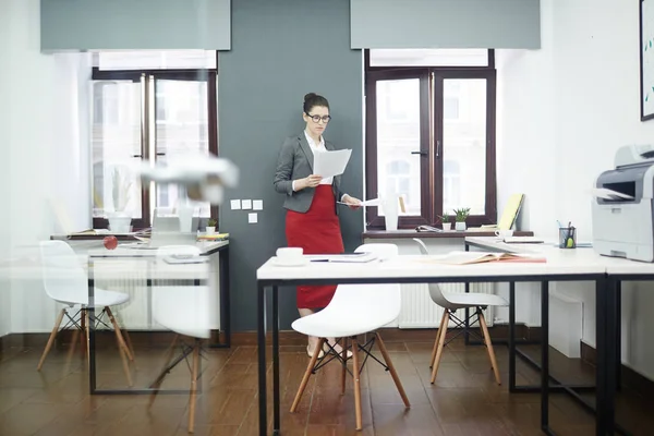 Jonge Zakenvrouw Lezen Van Financiële Kranten Door Muur Van Office — Stockfoto