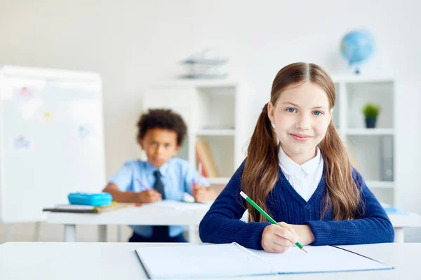 Adorabile Studentessa Con Pastello Seduta Alla Scrivania Con Compagno Classe — Foto Stock