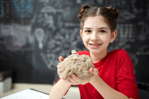 カメラ目線 子ども発達センターのキネティック砂で遊んで笑顔かわいい女の子の肖像画 — ストック写真