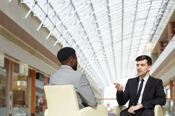 年轻成功企业家的肖像谈非裔美国人的商业伙伴 讨论现代办公大楼的工作 — 图库照片