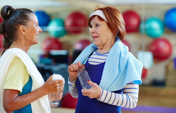 Активные Пожилые Женщины Бутылками Воды Разговаривают Тренажерном Зале — стоковое фото
