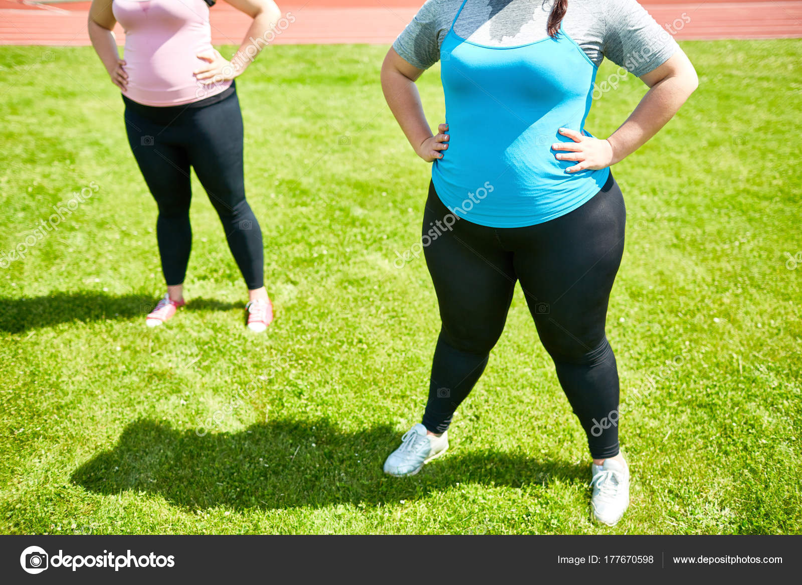 Two Sized Females Standing Akimbo Grass Workout Stock Photo by