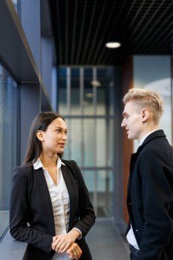 Güzel siyah saçlı beyaz yakalı işçi office lobide duran ve tartışmak onların ortak bir çalışma, bel, dikey onun erkek arkadaşı arıyorum