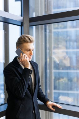 Onun telefon muhatap penceresindeki office lobisinin, bel, dikey duran bir konsantrasyon ile dinlerken sarışın ofis çalışanı