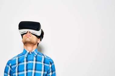 Genç adam yukarı oynarken seyir konsantre oyun Vr kulaklık, atış studio yardımıyla