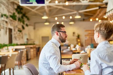 İki iş ortağı planları için gün kahvaltıya restoranda tartışıyor