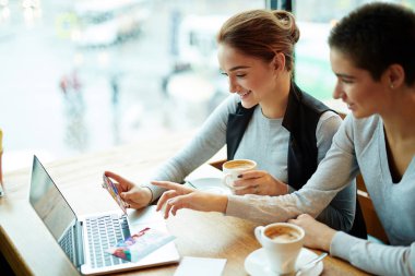 Görünüm gülümseyen arkadaşıyla kafede masada oturan ve onun fotoğrafları dikey, bel, tatilden gösterilen oldukça kısa saçlı kadın profil