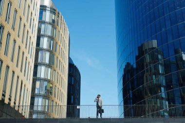 Modern tüccar gökdelenler arasında mavi gökyüzü karşı arama