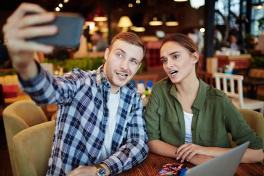 Güzel genç çift Tarih içinde rahat küçük kahvehane sahip: onlar modern smartphone selfie alırken surat