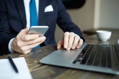Laptop ile çalışma ve işyerinde smartphone ağ süre tutarak zarif işadamı portresi portre