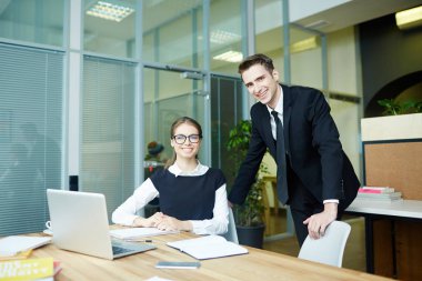 Toplantı odası üretken çalışma toplantısı yaparken fotoğraf için poz genç beyaz yakalı işçiler gülümseyen grup portresi