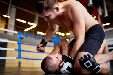 Profesyonel güreşçi halka bir boks mücadele portresi: onu yere mücadele karşısında isabet kanlı rakip dostum