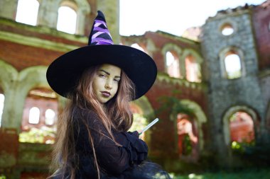 Sihirli değnek kamera karşısına eski püskü kalıntıları bakarak ile sinsi küçük cadı