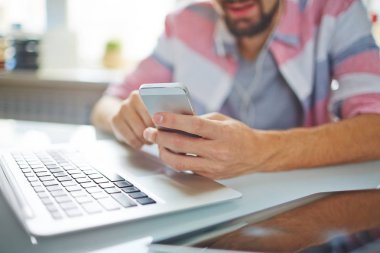 Sosyal medya kısa zaman laptop önünde oturan kırdı yapmak smartphone kullanarak işadamı Close-Up