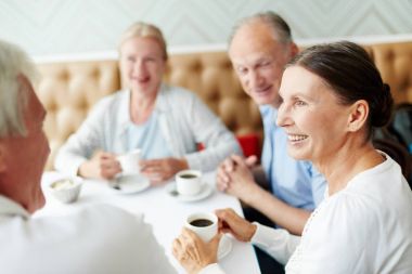 Cafe masa başına oturmuş ve fincan kahve konuşmayı kıdemli yoldaşları grup