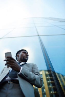 Adam açık havada iş ortağı için bekleyen smartphone ile