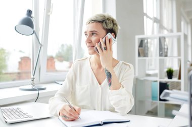 Smartphone ile konuşmak ve Notlar not defterinde yapım genç ofis çalışanı