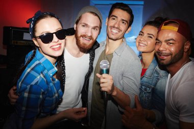 Genç insanlar dışarı asılı gece kulübünde parti ve sahip eğlenceli karaoke sahnede şarkı gülümseyen bir etnik grup