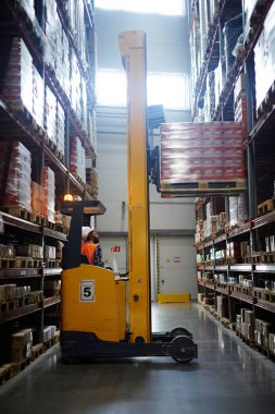 Yükleyici depo raf üzerinde paketlenmiş ürünler kaldırma