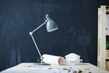 Arka plan resmini tasarımcıları çalışma masası, metal lamba ve planları blackboard modern ofis, kopya alanı karşı ev modeli ile