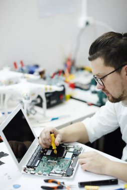 Tornavida ve farklı araçlar ile masa üstünde laptop yan görünüm portre atölye tamir modern insanın demonte