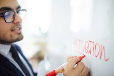 İşadamı ile kırmızı parlak beyaz tahta üzerinde yazılı kelime motivasyon altını çizme