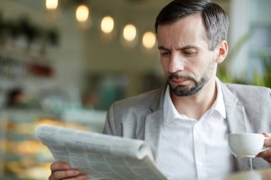 Ciddi işadamı kahve tarafından gazete okuma