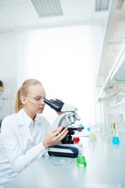 Tıbbi araştırma modern laboratuvar çalışma mikroskop kullanarak güzel kadın bilim adamı portresi