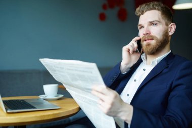 Profesyonel komisyoncu ile gazete ve kafede otururken cep telefonu