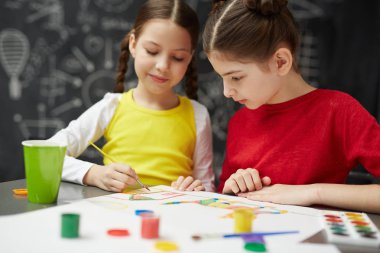 İki genç kız birlikte Sanat okulunda resim