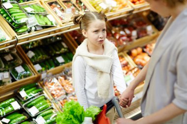Papatyanın kız annesi süpermarkette bakarak