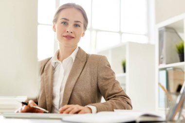 Kameraya bakarak iş sırasında resmi kıyafeti içinde genç öğretmen