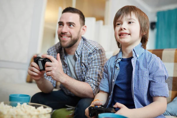 幸せな少年と彼のレジャーで再生中のビデオゲームの父します — ストック写真