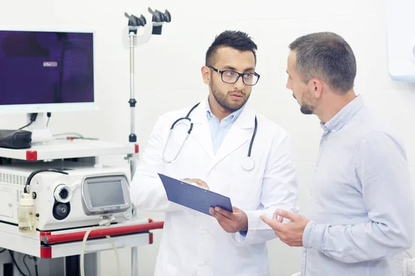 Bonito Jovem Médico Óculos Discutindo Resultados Exames Médicos Com Paciente — Fotografia de Stock