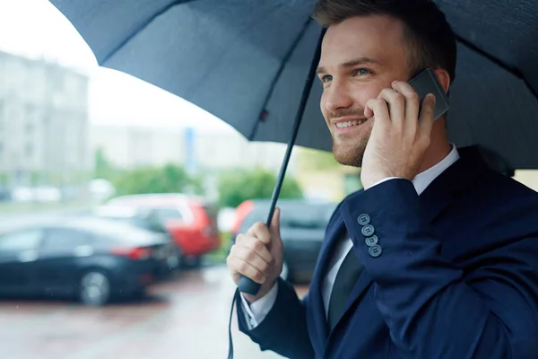 雨の日に電話でアポを取って成功するリーダー — ストック写真
