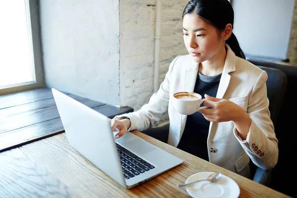 Upptagen Ung Kvinna Med Kopp Kaffe Sitter Framför Laptop Och — Stockfoto