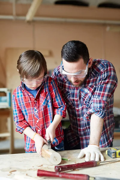 小男孩 Woodcrafting 而他的父亲咨询他 — 图库照片