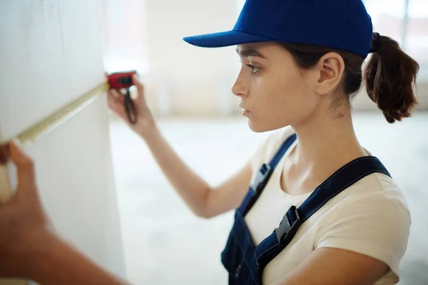 Side View Portrait Young Pretty Woman Wearing Uniform Measuring Walls — Stock Photo, Image