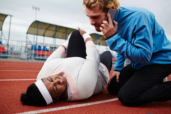 Plump Woman Injured Leg Lying Running Track Her Trainer Comforting — Stock Photo, Image