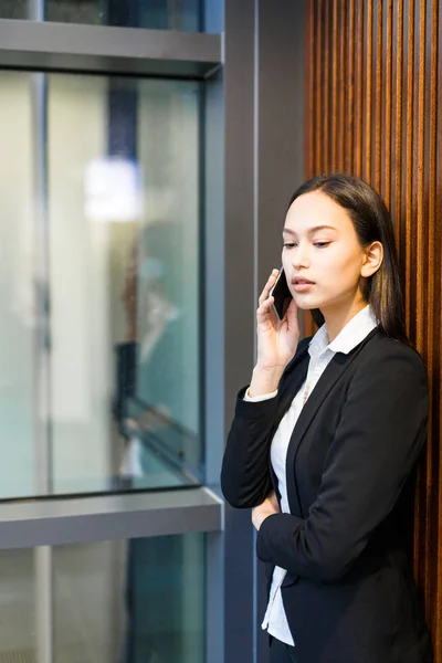 Mieszane Rasy Młoda Kobieta Interesu Odpowiadanie Telefon Podczas Gdy Pochylony — Zdjęcie stockowe