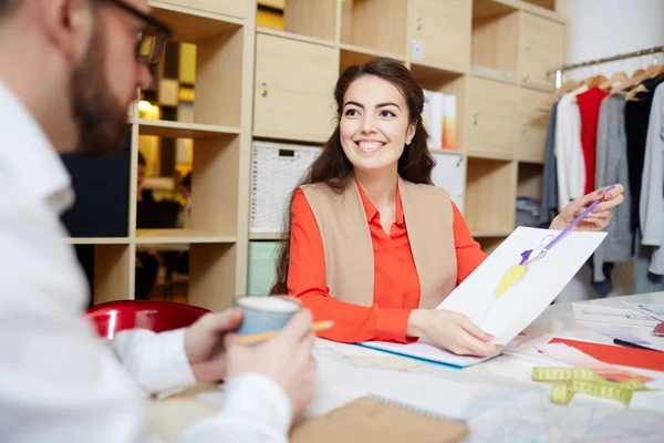 Dressmaker Indicando Schizzo Durante Consultazione Con Suo Collega — Foto Stock