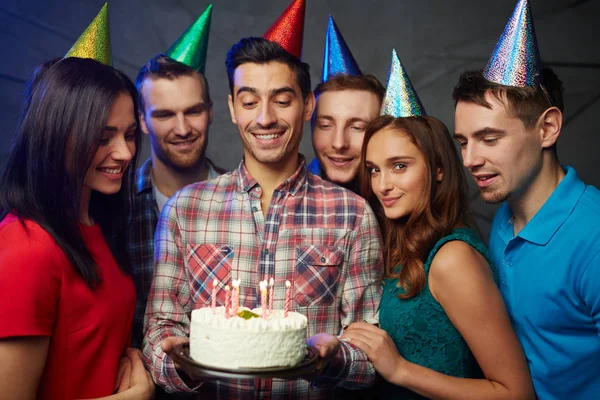 快乐的年轻朋友看着在美味的生日蛋糕上燃烧蜡烛 — 图库照片
