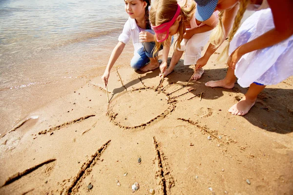 Chicas Amistosas Dibujando Sol Arena Junto Agua Caluroso Día Verano —  Fotos de Stock