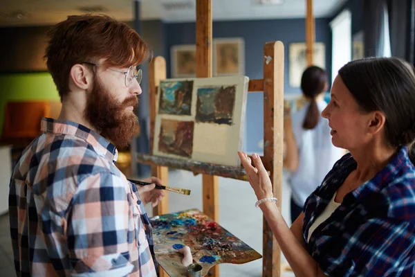 Experienced Teacher Consulting Her Student Pointing His Painting — Stock Photo, Image