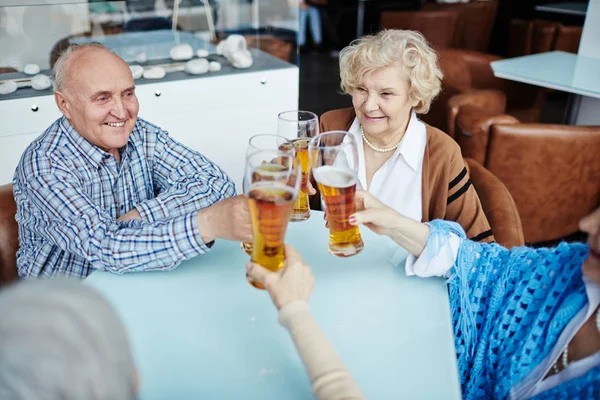 Cuatro Ancianos Alegres Sentados Acogedor Pub Colgando Vasos Cerveza Junto —  Fotos de Stock