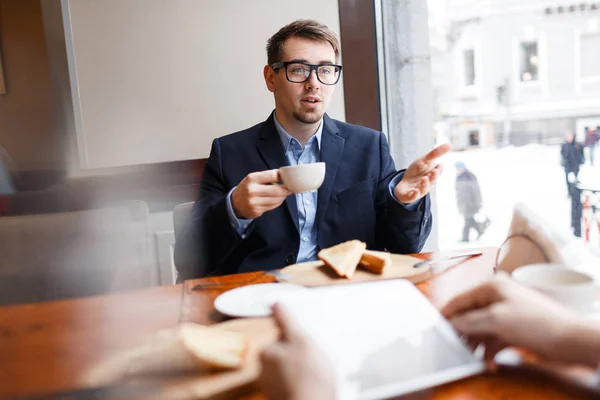 年轻的专业与杯茶向同事解释他的想法杯茶 — 图库照片