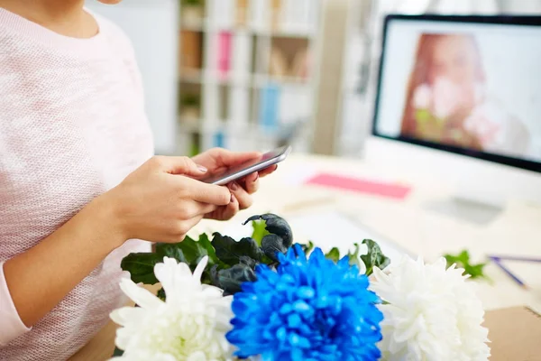 女性手中的花卉设计师手持现代智能手机和拨号业务合作伙伴 特写镜头 — 图库照片