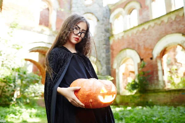 Menina Bruxo Preto Segurando Abóbora Esculpida Madura Com Vela Acesa — Fotografia de Stock