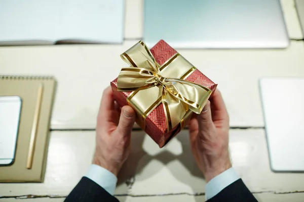 红色小礼品盒与金色丝带在人的手 — 图库照片