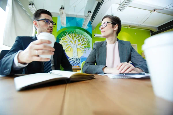 つのビジネス パートナー男性と女性の近代的なオフィスで会議中に作業を議論のローアングル ショット — ストック写真